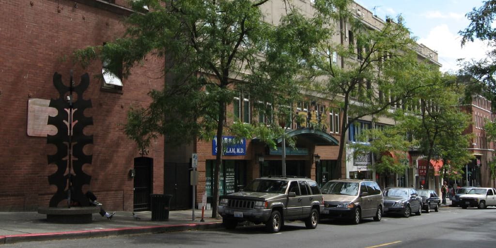 Street in Seattle's C/ID with brick building and street trees