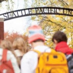 students walking outside under archway that says "Seattle Pacific University"