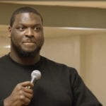 African-American man speaking into microphone