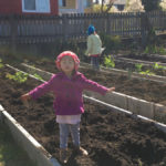 woman and child standing in large community garden