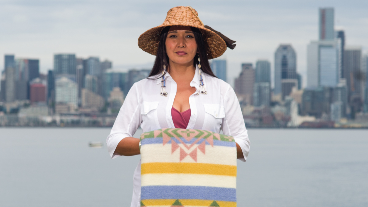 Sondra Segundo, standing outside with Seattle skyline in the background