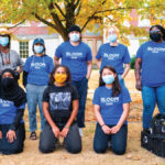 group of Black, Indigenous, and people of color community members, wearing masks, standing outside at cider pressing event
