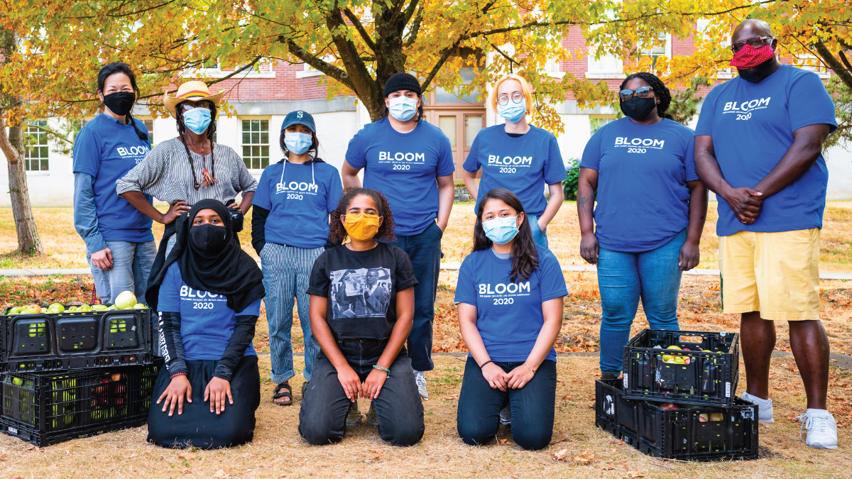 group of Black, Indigenous, and people of color community members, wearing masks, standing outside at cider pressing event