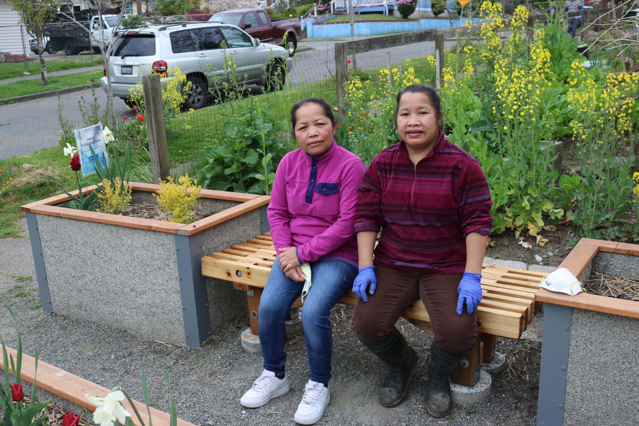 Rangkham’s daughters Boukham and Suangrang sitting on the bench at the memorial garden