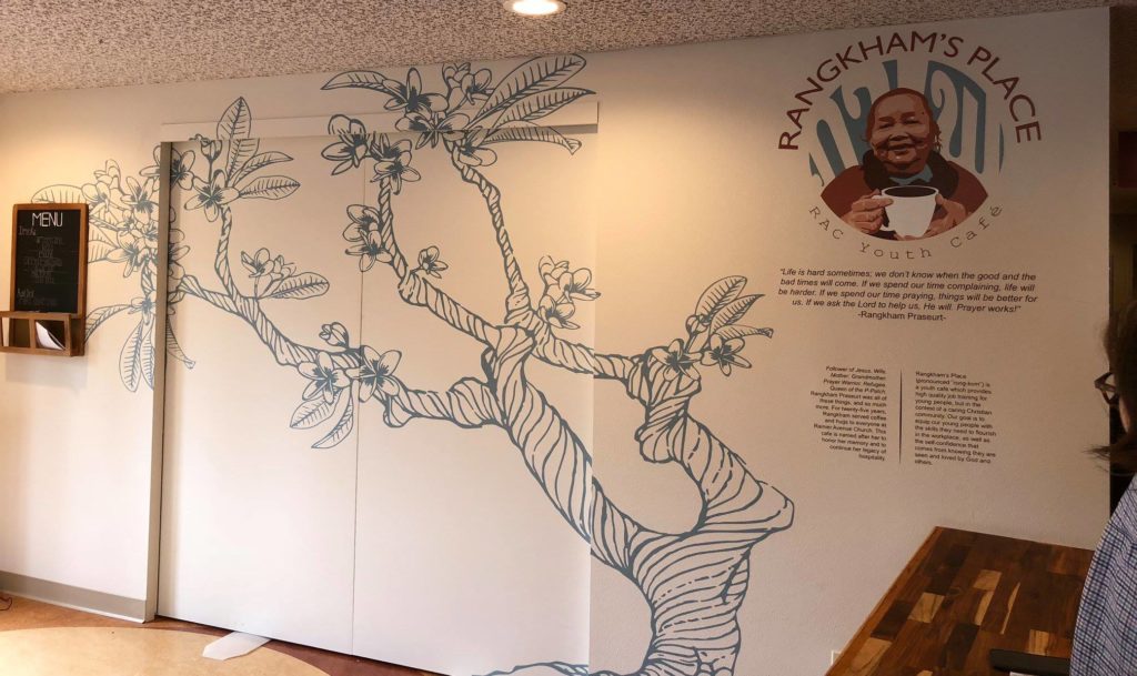 interior wall of Rangkham's Place cafe with mural of a plant and illustration of Rangkham's face
