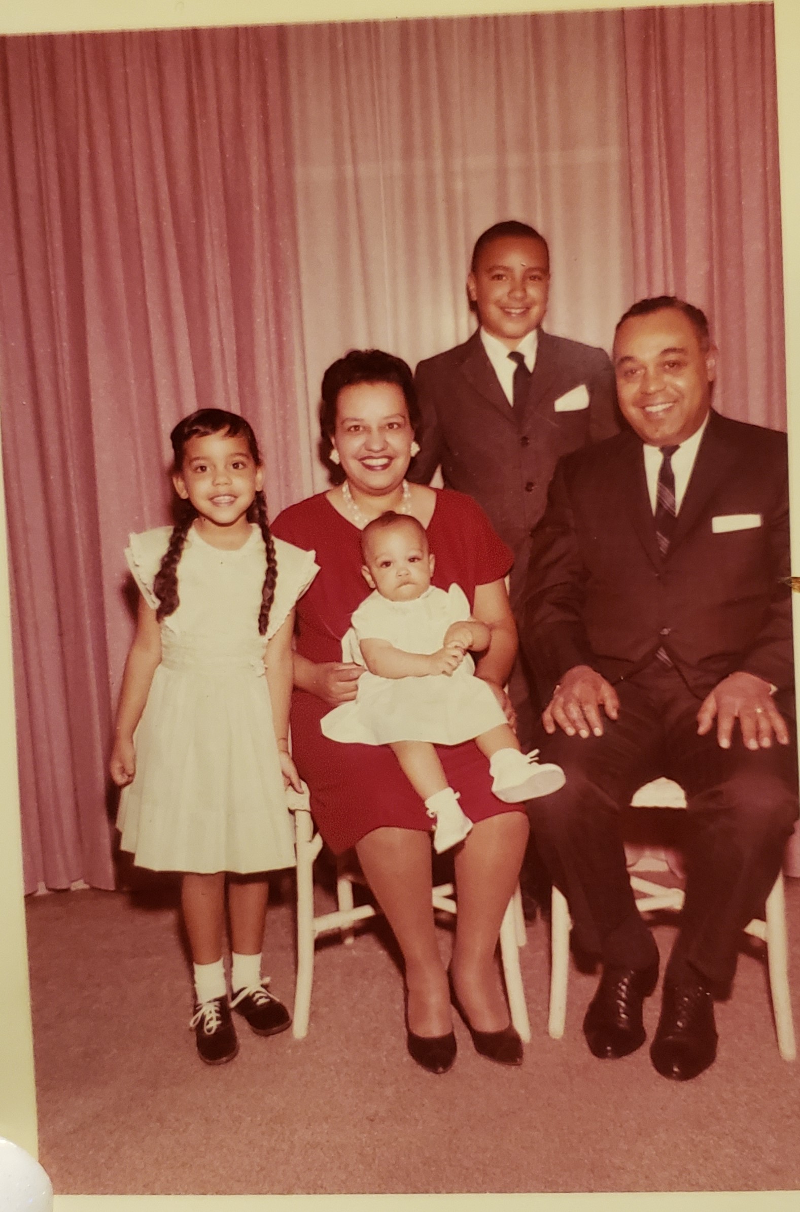 Allen family photo from 1963. a man and woman seated in chairs, two children standing, and a baby in the woman's lap. they are all wearing formal attire and smiling.