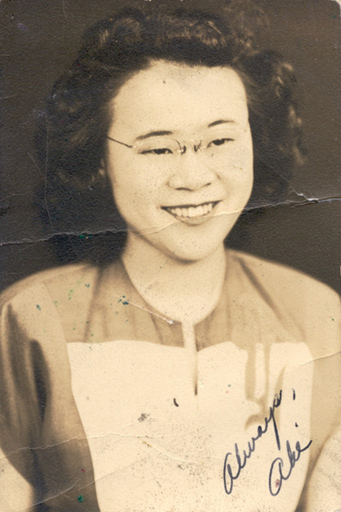young woman with short black hair and glasses. She is smiling.