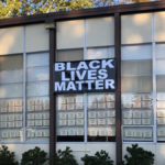 Picture of retro, 50's style window glazing with notes hung in each window and a large banner stating, "Black Lives Matter."