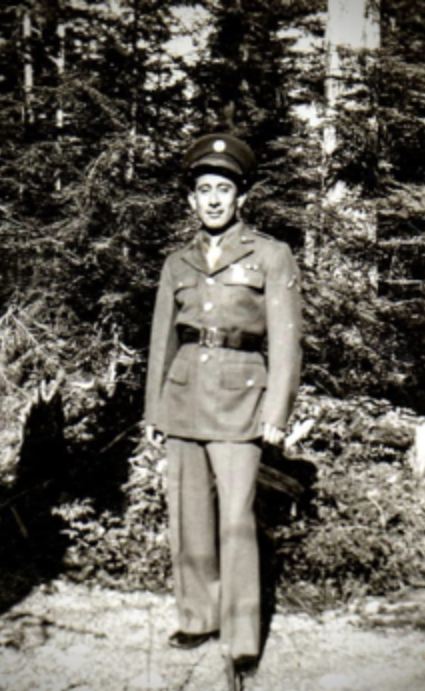 black and white photograph of a man standing outside in military uniform