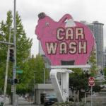 revolving neon sign of a pink elephant with the words "CAR WASH"