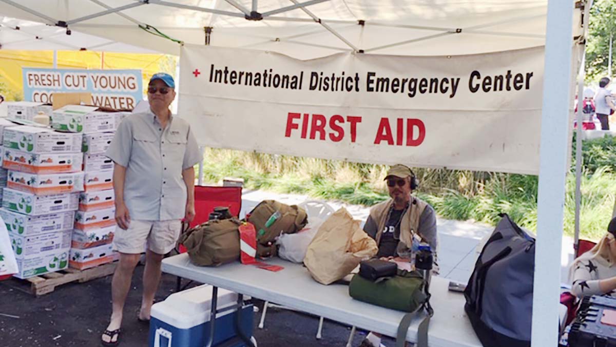 A person standing next to a table with first aid equipment and a sign that says 