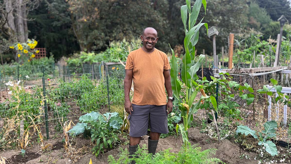 bald black man wearing shorts standing in a garden