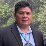 photo of Native American man in button-up shirt and blazer