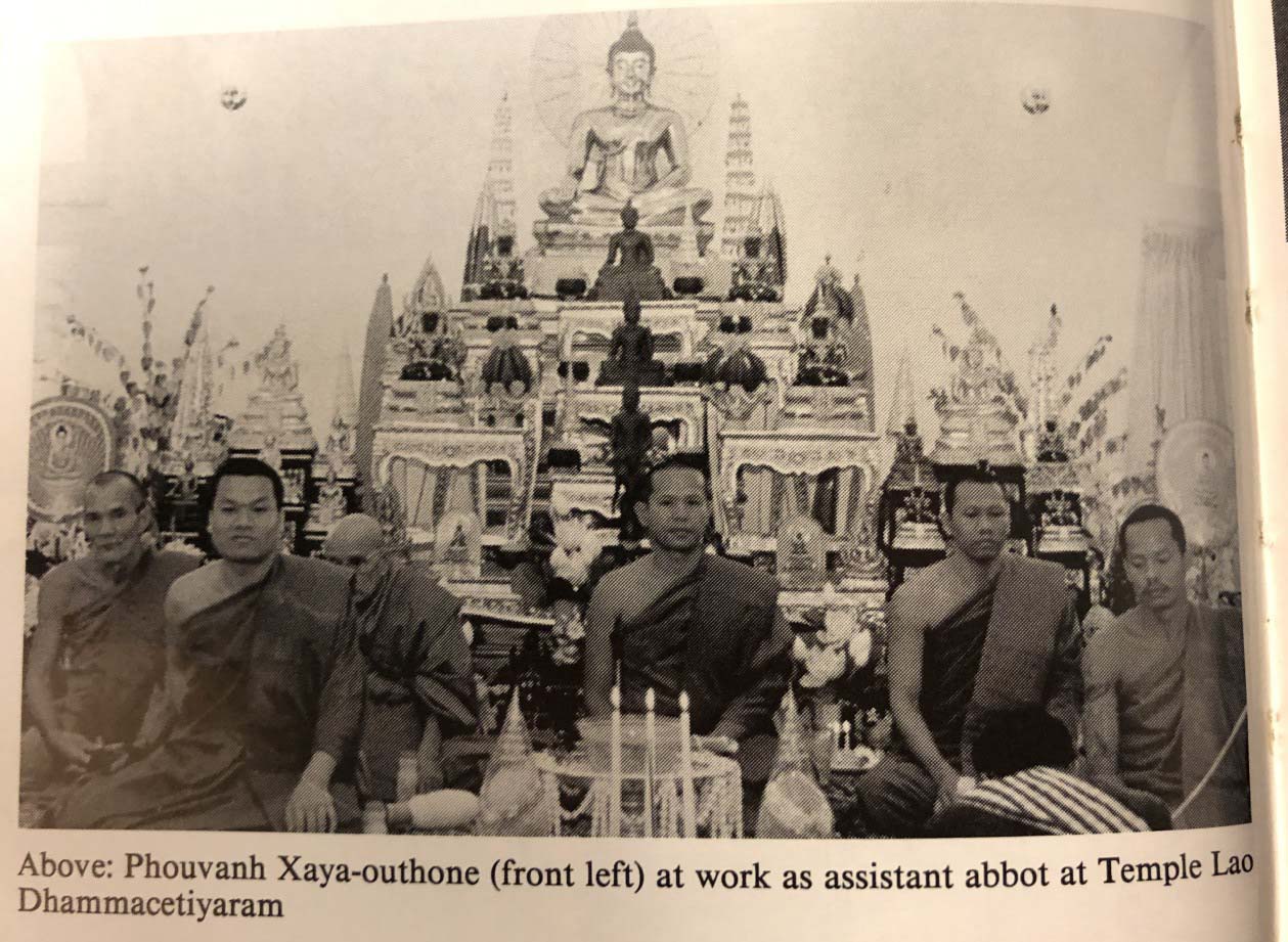 A black and white photo of a group of monks sitting in front of an ornate temple with statues of the Buddha. 