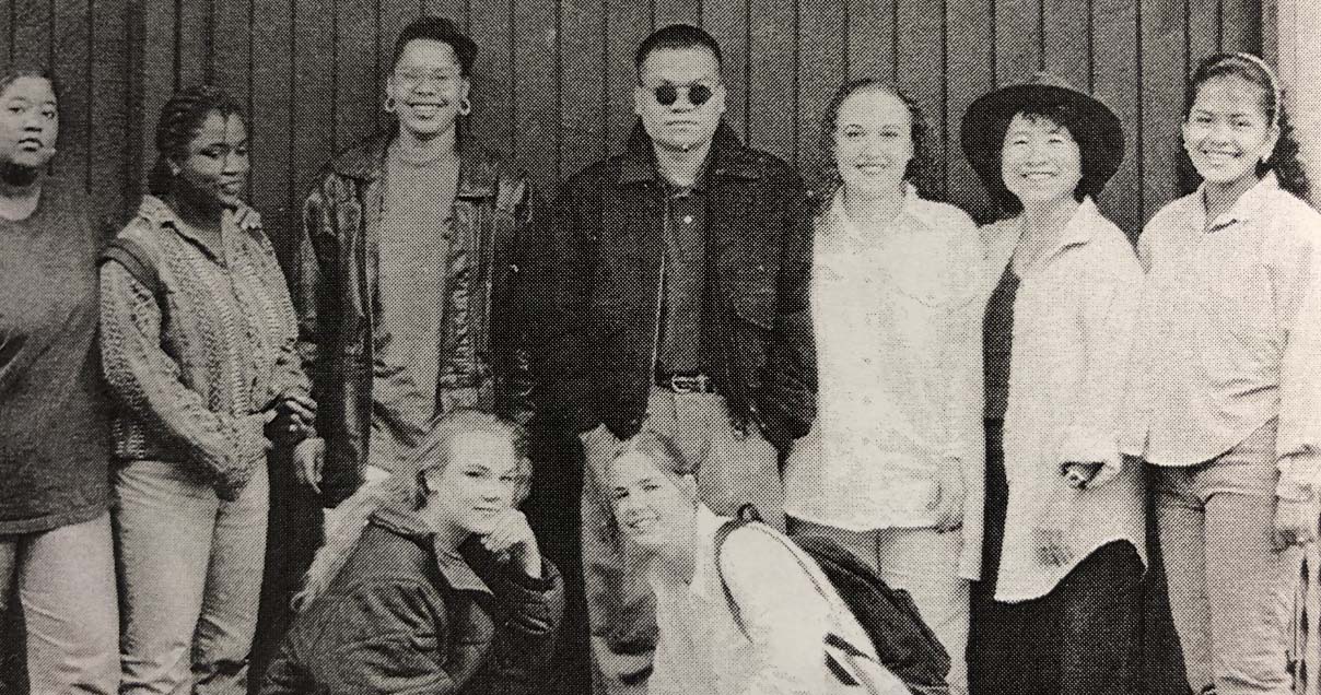 A black and white photo of group of teens and their teacher, Betty Lau, with Von in the center dressed in layperson clothing. 