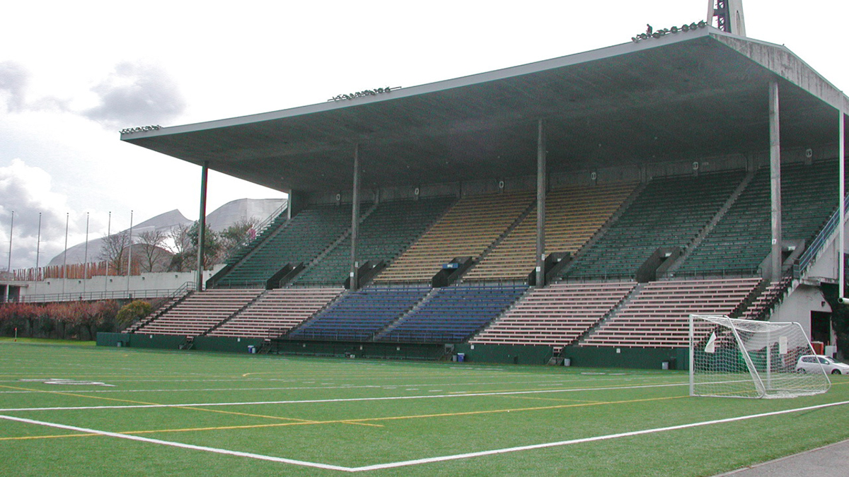 photograph of concrete stadium seating structure with football field in foreground