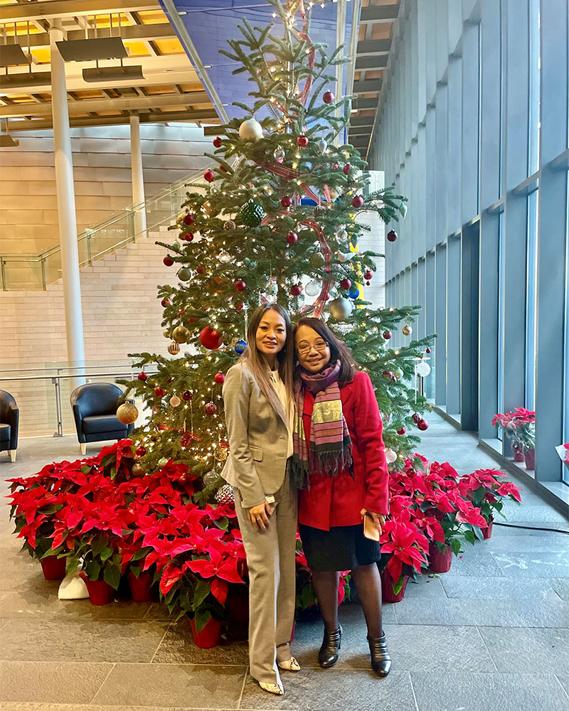Jenifer Chao poses with her mom in front of a Christmas tree in the lobby of City Hall.