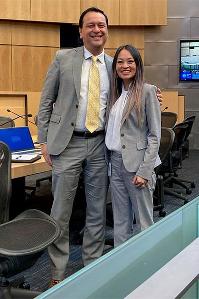 Deputy Mayor Greg Wong stands with Director Jenifer Chao in Seattle City Council chambers.