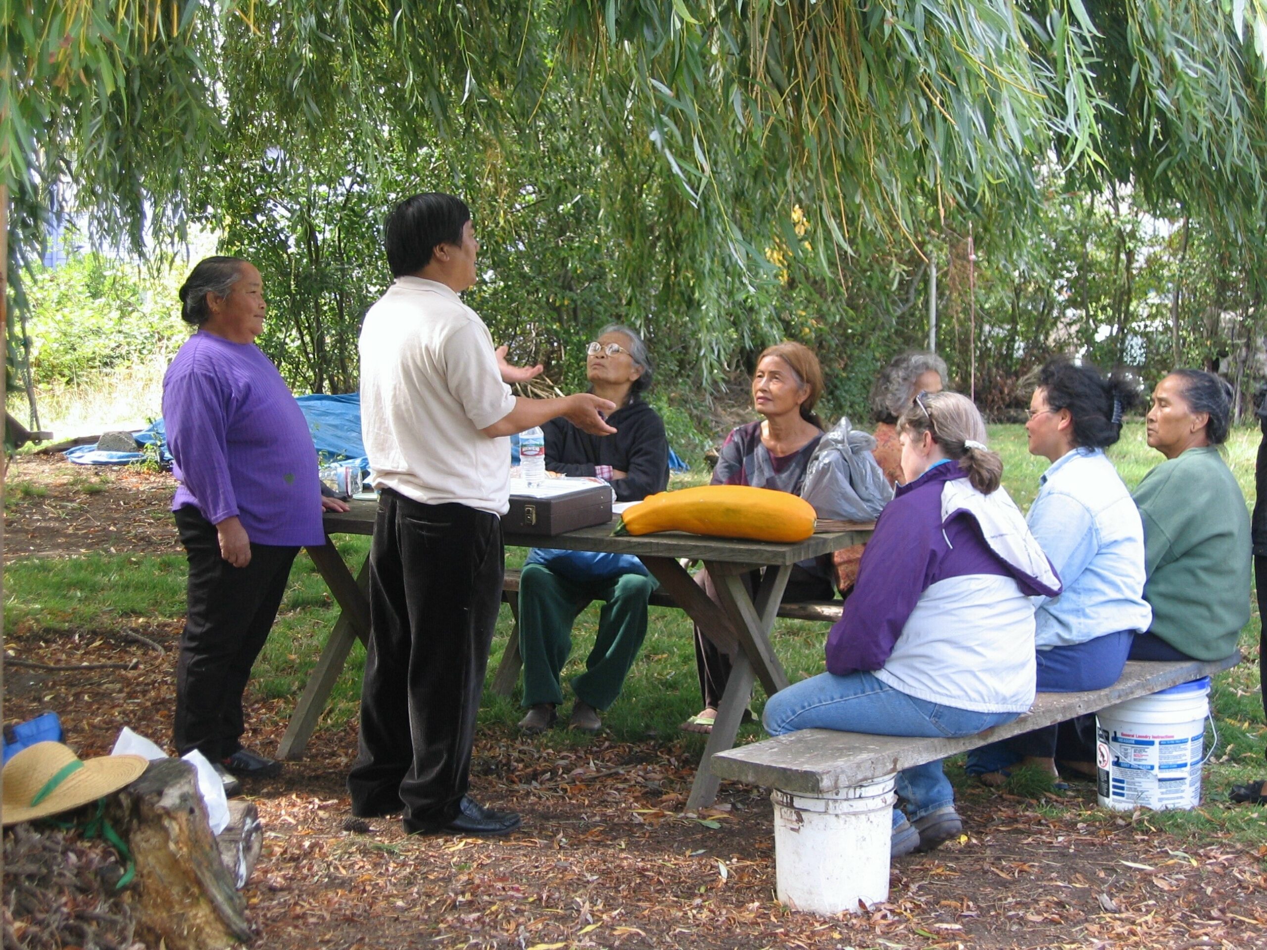 Yao Fou talking to a group of senior citizens in the garden. 