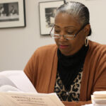 Woman wearing glasses is reading documents.