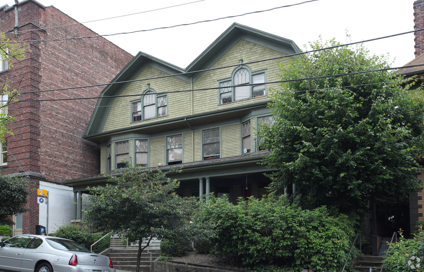 Conjoined houses with three stories and pointed roofline.