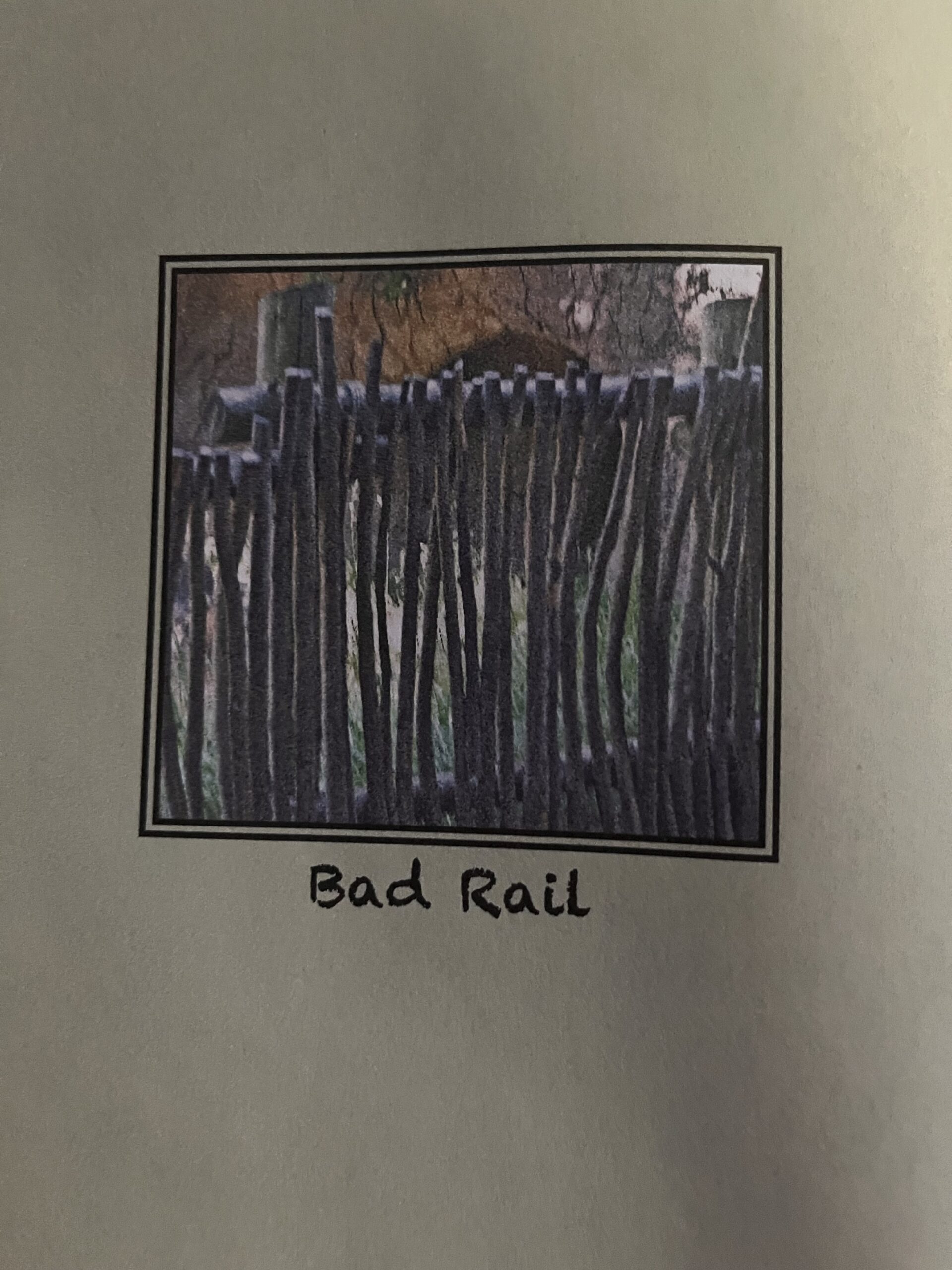 A photo in the center of a book page of a wood railing with vertical wood slats and text beneath that says "Bad Rail" 