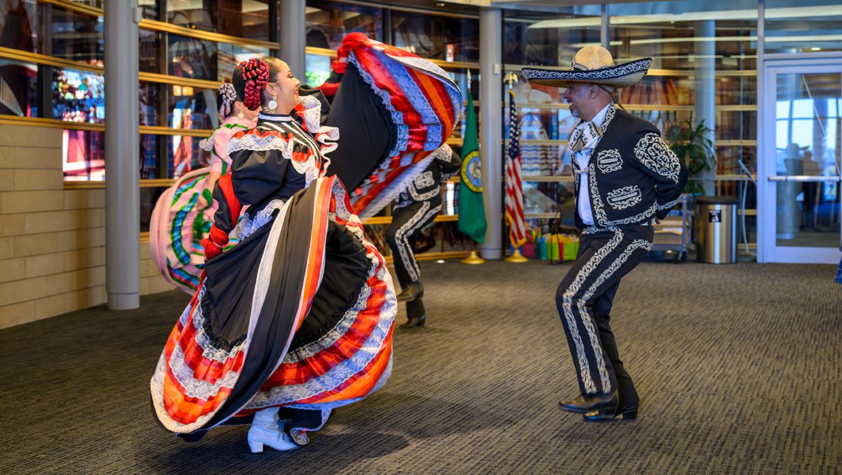 Two dancers in traditional Mexica outfits performing