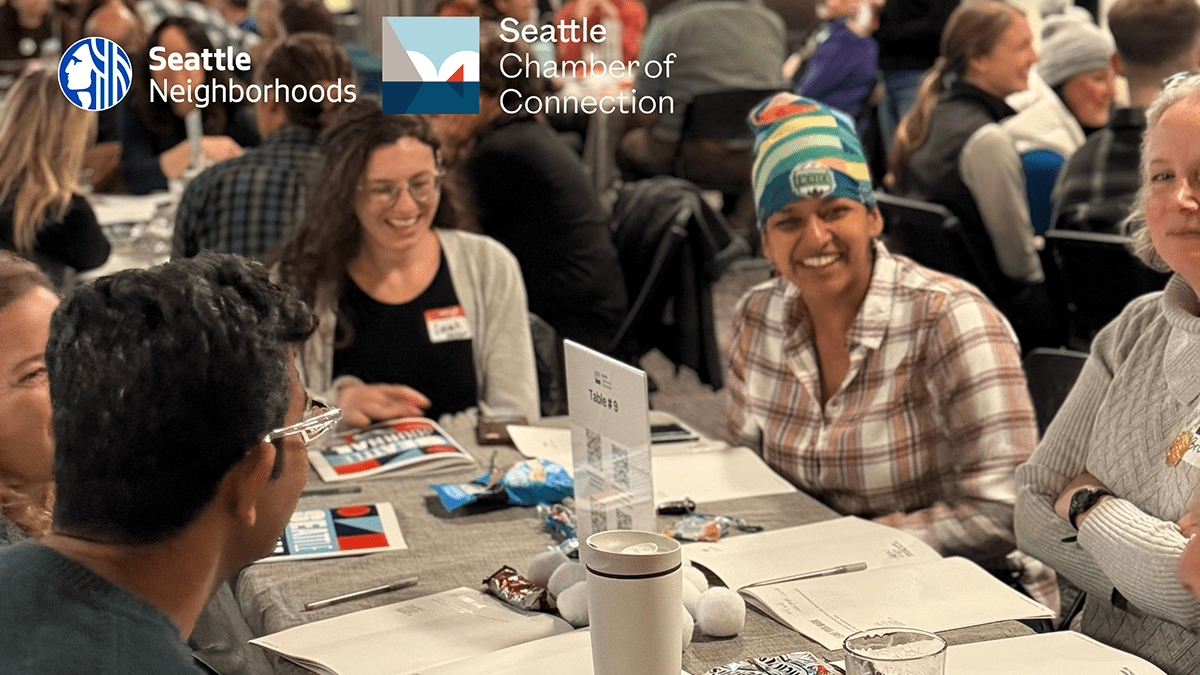 Five people sitting around a table engaged in conversation.