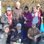 A group of nine people posing for a photo outdoors. Graphic text in the upper left corner says: "Have We Met" and text in the lower left reads: "Karen Ko" with an arrow pointing to a woman kneeling