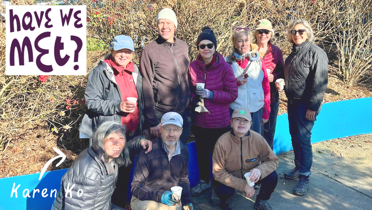 A group of nine people posing for a photo outdoors. Graphic text in the upper left corner says: 