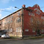 exterior view of a three story historic brick building on the corner of a city street