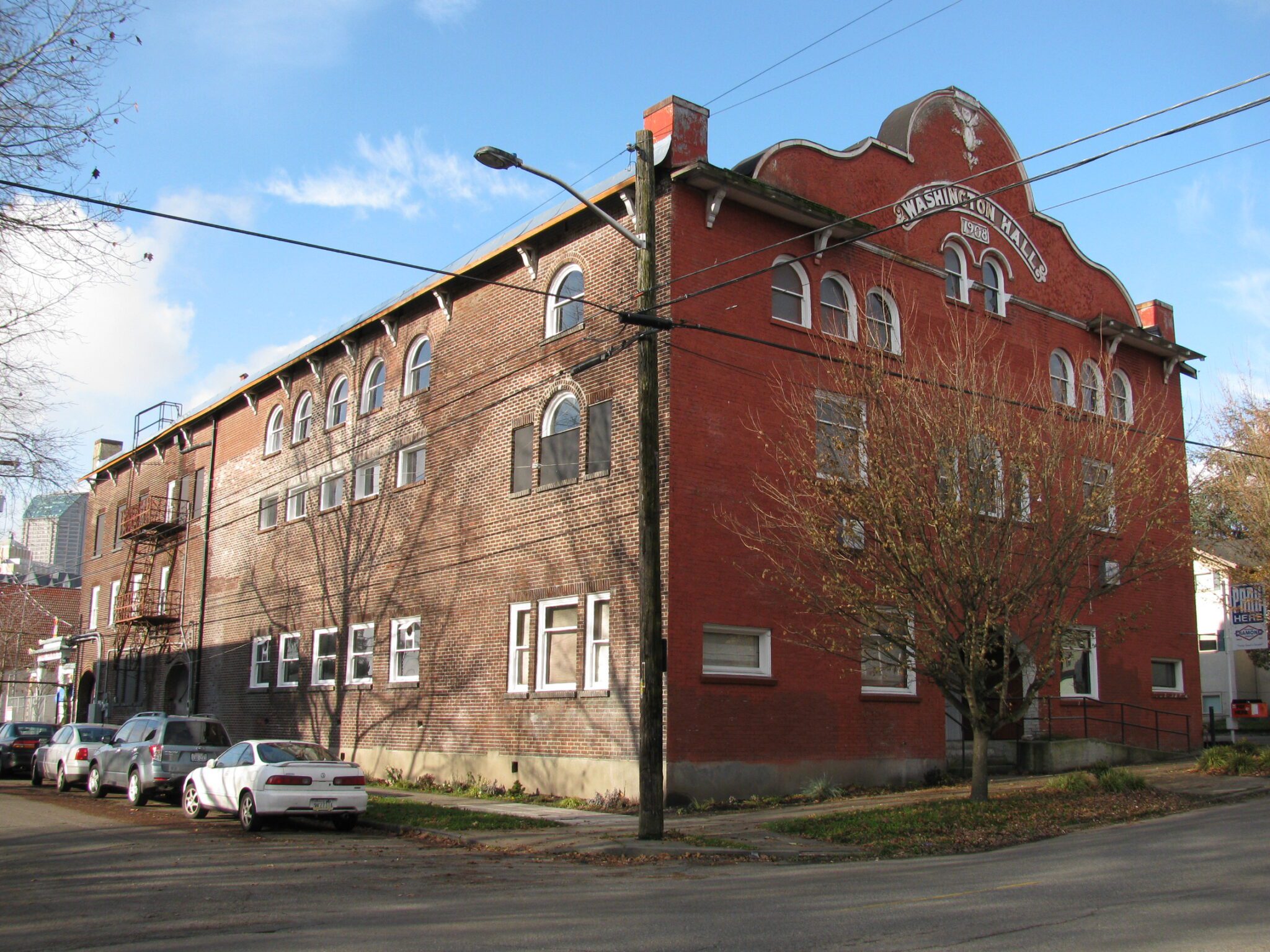 exterior view of a three story historic brick building on the corner of a city street