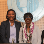 Four women standing together under the City of Seattle crest