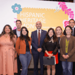 City of Seattle officials stand together in front of a sign that reads "Hispanic Heritage Month"